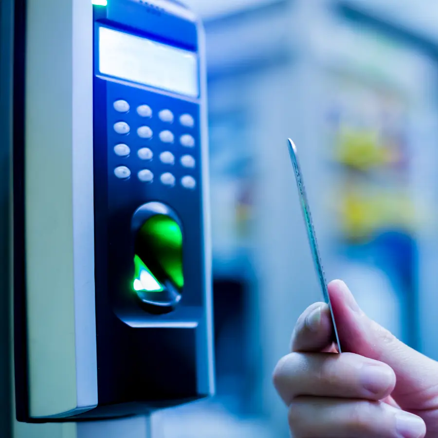 Pracownik przykłada kartę RFID do elektronicznego czytnika RCP z klawiaturą i czytnikiem linii papilarnych, zintegrowanego z systemem SyKOF HR.