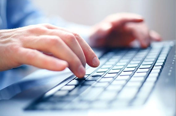Dłonie piszące na klawiaturze komputera - wprowadzanie danych do systemu podczas pracy biurowej